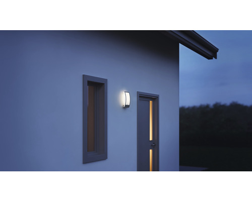 Vonkajšie nástenné svietidlo vedľa okna a dverí na stene domu