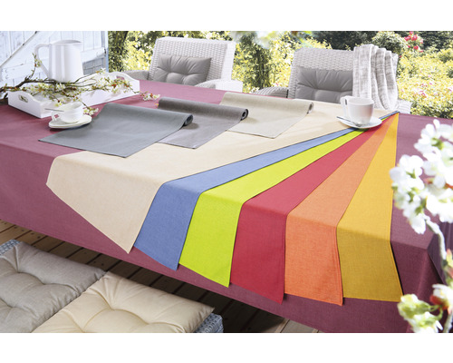 Prestretý stôl s obrusmi rôznych farieb na vonkajšie použitie.