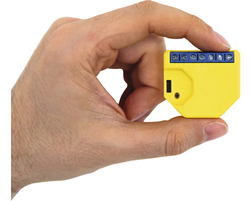 Žltý inteligentný domáci spínač v ruke