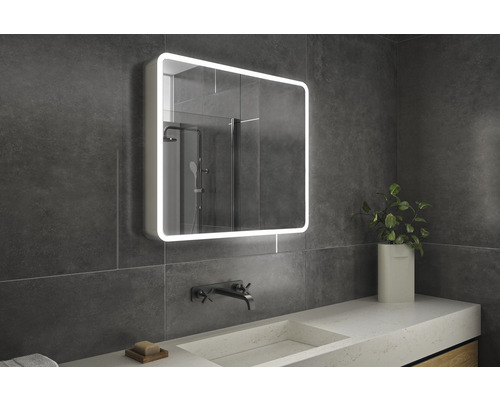 Kúpeľňa s osvetlenou zrkadlovou skrinkou, umývadlom a vodovodnou batériou.