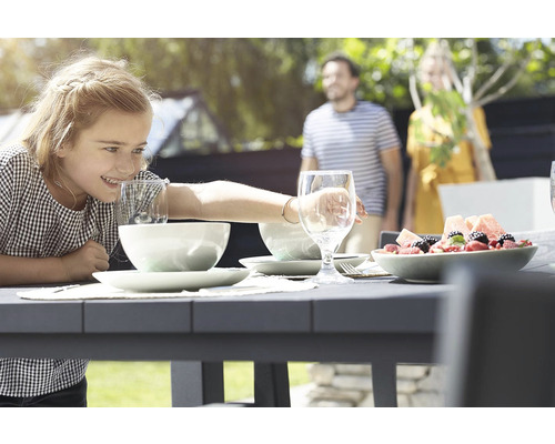 Vonkajšia scéna s jedálenským stolom, riadom, nápojmi a rodinou