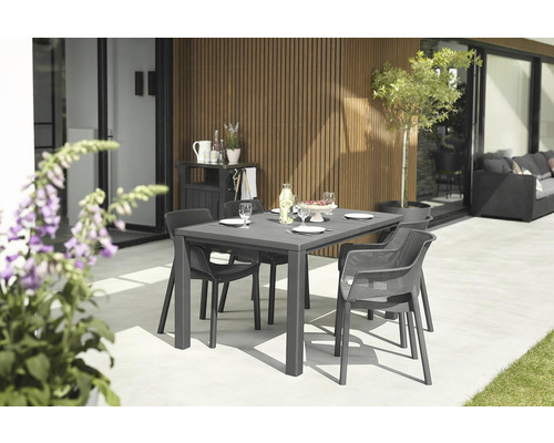 Záhradná scéna s jedálenským stolom a stoličkami na terase.