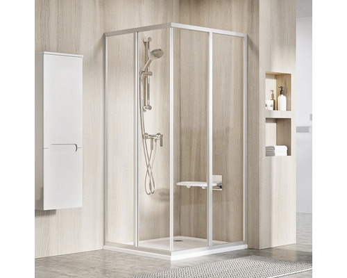 Rohová sprcha so sedadlom, sprchovou batériou a bielym kúpeľňovým nábytkom