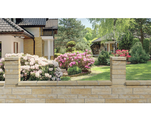 Betónový plot Bellamonte 60 x 20 x 10 cm medová melírovaná Kamenný záhradný múr s kvetmi a domom v pozadí