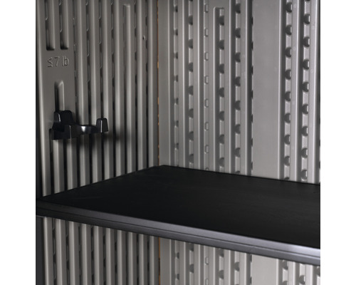 Vnútorný pohľad na záhradnú skriňu s policou a háčikmi na uloženie náradia a záhradníckeho vybavenia.