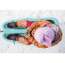 Dieťa leží na saniach v snehu.