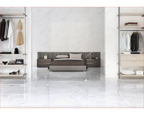 Spálňa s bielymi mramorovými dlaždicami, posteľou a otvorenými skriňami