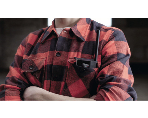 Osoba s bezpečnostným zariadením pre osamelých pracovníkov vo vrecku košele.