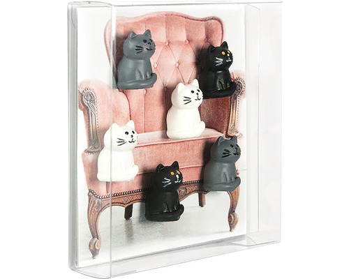 Dekoratívne magnety v tvare mačiek pred obrázkom stoličky