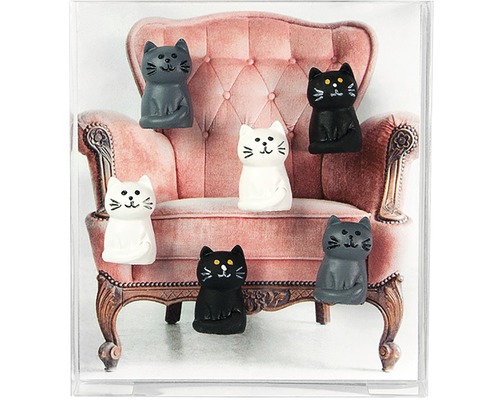 Dekorácia s mačacími figúrkami pred kreslom