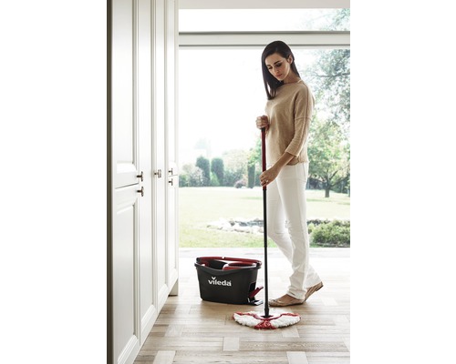 Žena vytiera drevenú podlahu mopom a vedrom Vileda