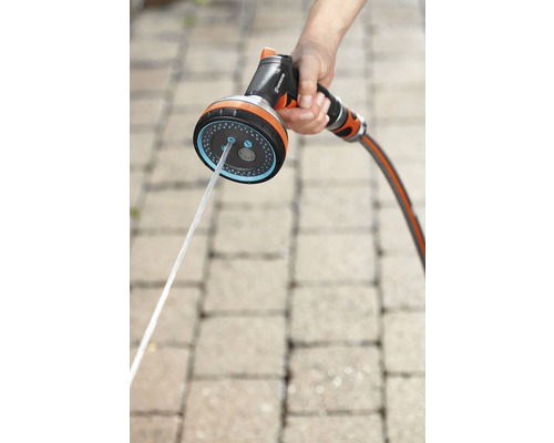 Záhradná hadica s rozprašovacou hlavicou v ruke