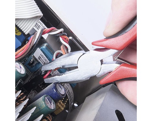 Kombinované kliešte strihajú kábel v elektronickom zariadení.