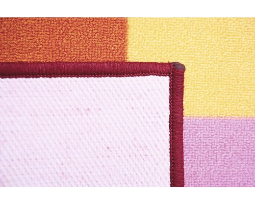 Detail farebného kúpeľňového koberca s geometrickým vzorom