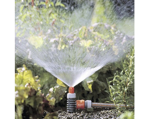 Záhradná scéna s bežiacim obdĺžnikovým zavlažovačom na zavlažovanie záhrady