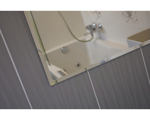 Detail zrkadla na stene kúpeľne s obkladmi