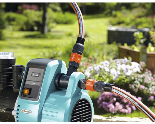 Záhradné vodné čerpadlo s pripojenými záhradnými hadicami vo vonkajšom prostredí