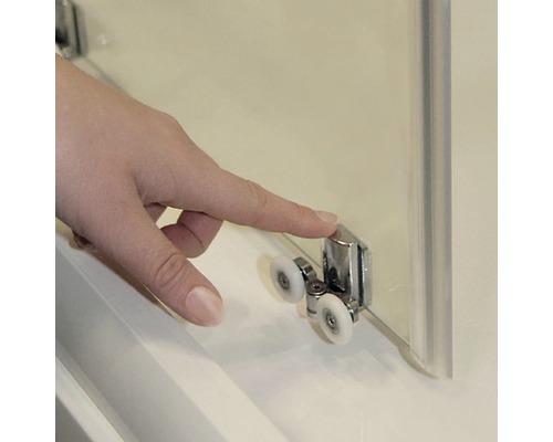 Detailný záber sprchovacieho kúta s prstom na rolovacom mechanizme