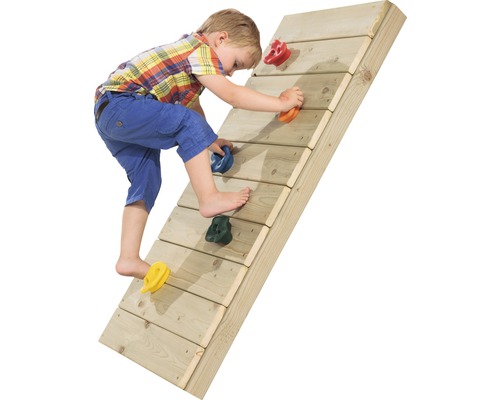 Dieťa lezie na drevenú lezeckú stenu s farebnými lezeckými úchytmi.