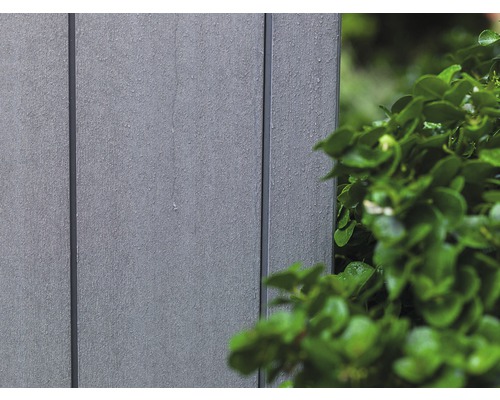 Detail plastového obkladu fasády vedľa zelenej rastliny