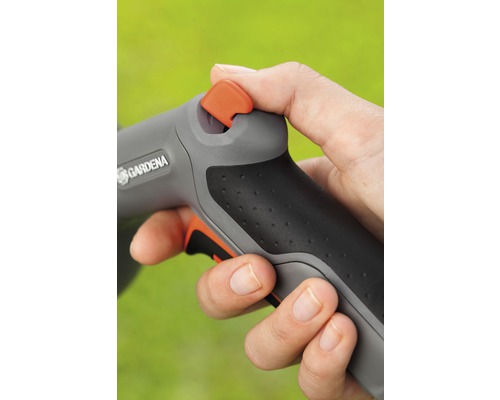 Ruka ovláda záhradnú striekaciu pištoľ značky Gardena.