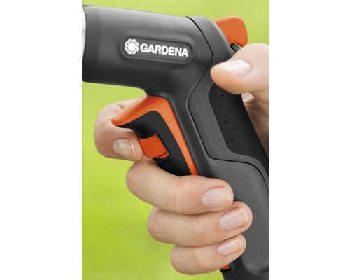 Ruka drží záhradnú striekaciu pištoľ s logom Gardena