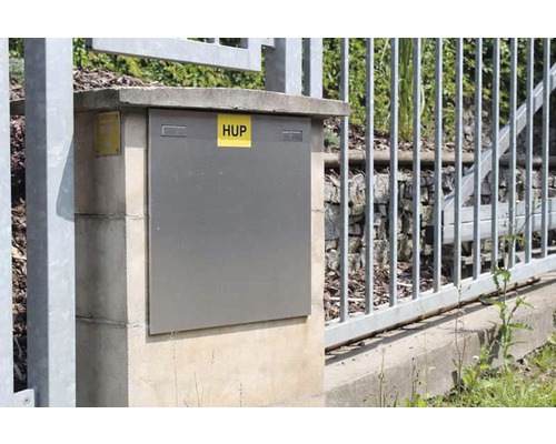 Skriňa domovej odovzdávacej stanice vedľa plota.