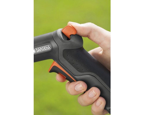 Detailný pohľad na ruku ovládajúcu záhradnú hadicu s logom Gardena