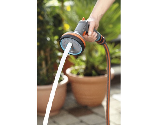 Osoba drží viacúčelovú sprchu Gardena s prúdom vody