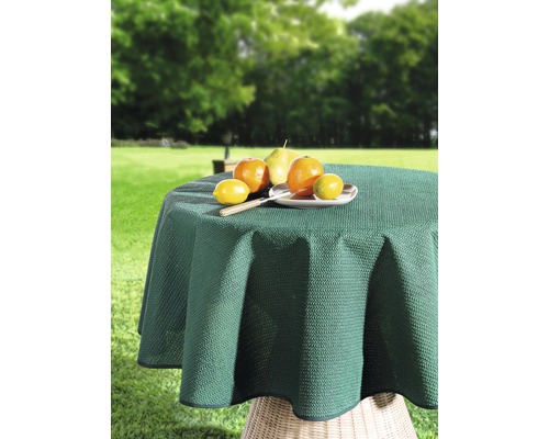Okrúhly záhradný stôl so zeleným obrusom a ovocím