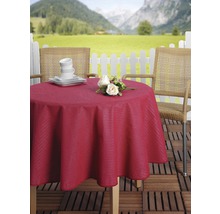 Prestretý záhradný stôl s červeným obrusom, riadom, kvetmi a dvoma stoličkami vonku s horami v pozadí.