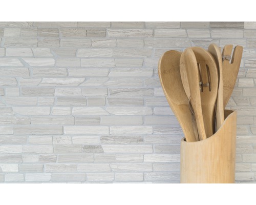 Drevené kuchynské náčinie v držiaku pred kamennou stenou