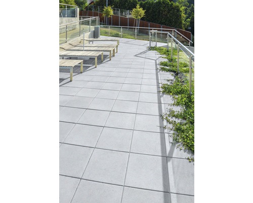 Terasa s betónovými dlaždicami a posedením.