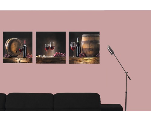 Dekoratívne trojdielne nástenné maľby s motívmi vína nad čiernou pohovkou.
