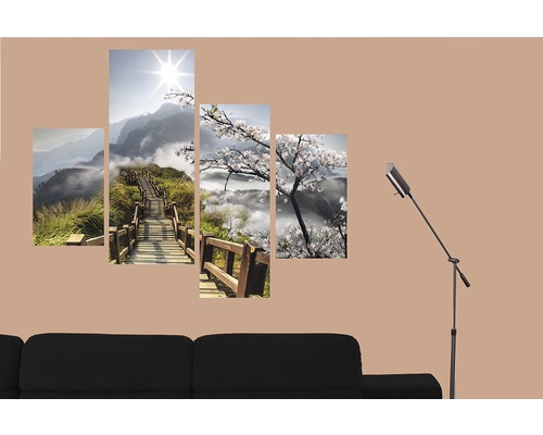 Viacdielny nástenný obraz s horskou krajinou a čerešňovými kvetmi nad pohovkou a stojacou lampou