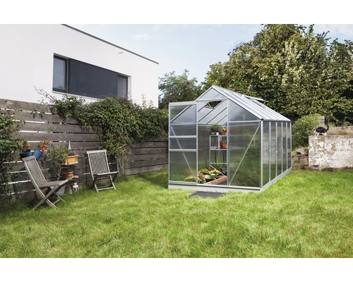 Skleník Vitavia Venus 6200 polykarbonát 4 mm 195x321 cm hliník vr. základového rámu Skleník v záhrade s otvorenými dverami a policami na rastliny.