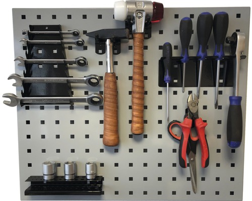 Dierovaná stena na náradie s kladivami, kľúčmi, skrutkovačmi, kliešťami a nástrčnými kľúčmi