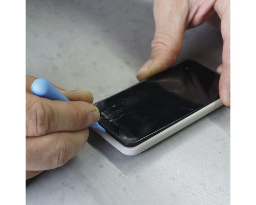 Remeselník opravuje smartfón nástrojom, poškodený displej