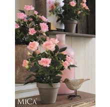 Dekoratívne ruže v kvetináči na stole s drevenou dekoráciou v tvare vtáka a vázou.