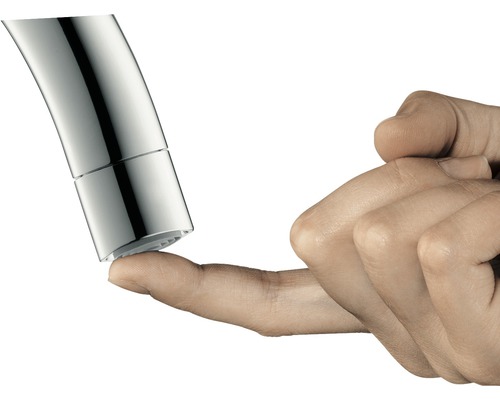 Detail konca vodovodnej batérie, ktorého sa dotýka prst