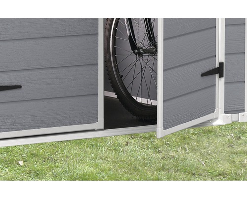 Detailný pohľad na otvorený úložný priestor na záhradné náradie s bicyklom vo vnútri.