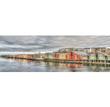 Panoramatický pohľad na farebné drevené domy na nábreží v Nórsku.
