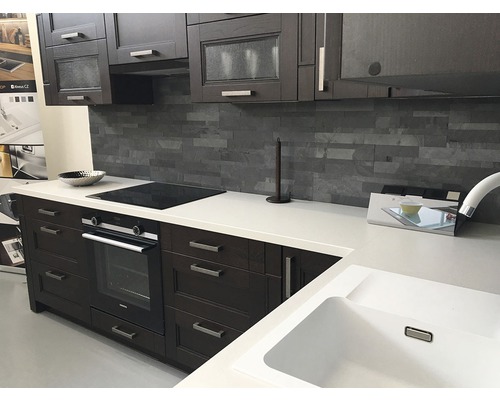 Moderná kuchyňa s tmavými drevenými skrinkami, bielou pracovnou doskou, drezom a elektrickými spotrebičmi