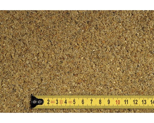 Detailný záber piesku na hranie so žltým zvinovacím metrom na indikáciu veľkosti.