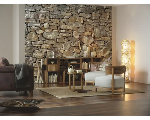 Obývacia izba s kamennou stenou, drevenou policou a sedacím nábytkom na koberci