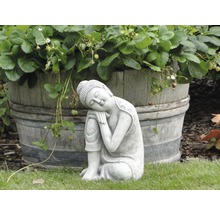 Kamenná soška Budhu vedľa dreveného suda s jahodníkmi