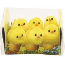 Dekoratívne žlté kuriatka v priehľadnej nádobe ako veľkonočná dekorácia