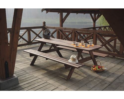 Drevený piknikový stôl s lavicami na terase s výhľadom na jazero.