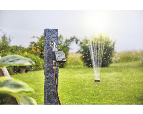 Zavlažovací systém s pripojením na vodovodný kohútik, zavlažovacím počítačom a zavlažovačom trávnika v záhrade