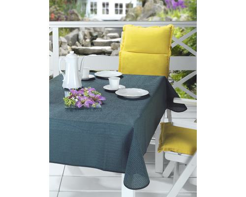 Scéna s prestretým stolom vonku s obrusom, riadom, kvetmi a vankúšmi